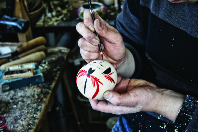 Teruyuki Hiraga paints the kokeshi's facial expression