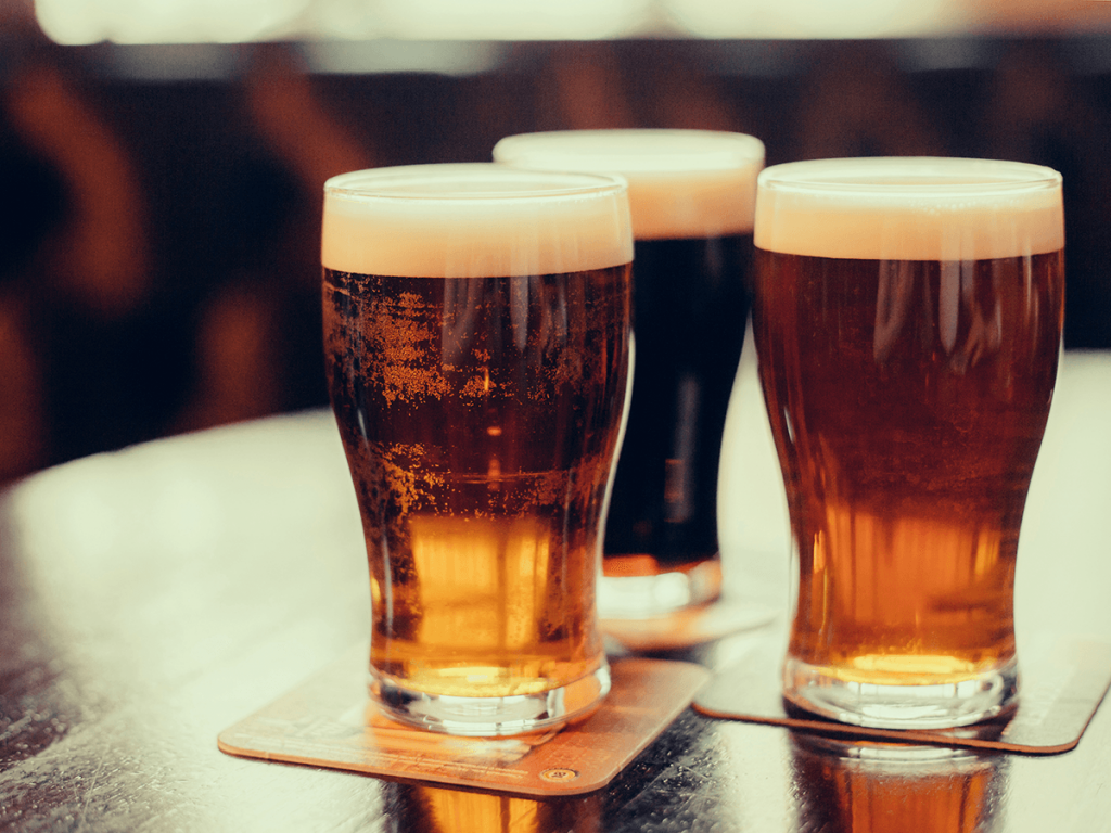 three glasses of beer at a pub