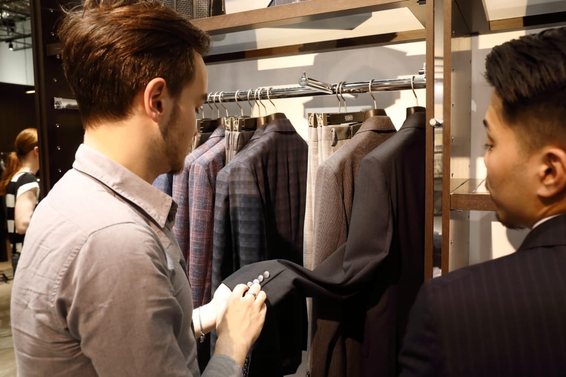 Customer looks at D'URBAN men's suits Tokyo Weekender